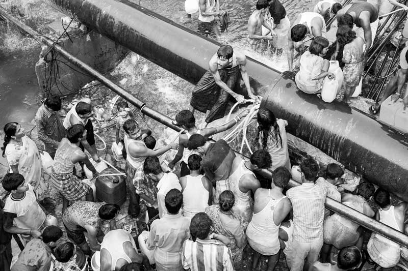 Human Right to Water in Delhi - Water being procured from a pipeline leakage near a cluster of slum and unauthorized colonies in Delhi
